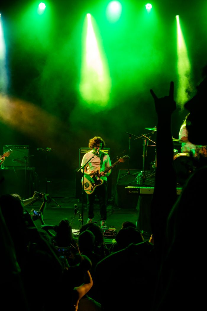 A dynamic live concert scene with a guitarist on stage under vibrant lighting. Perfect for music-related themes.